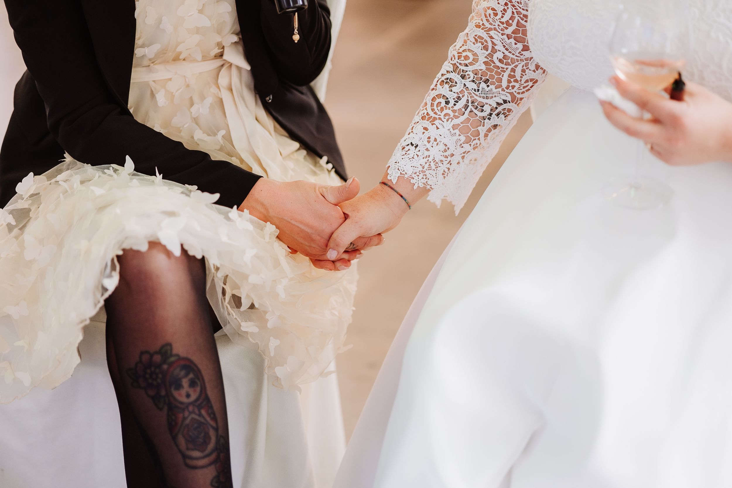 Delicate white lace sleeve detail on a wedding dress shows intricate floral patterns against light fabric.