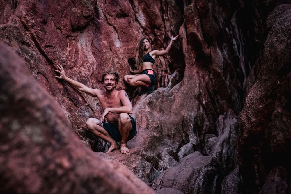 Rock climbers navigate through pink-tinted rocky terrain during an outdoor climbing expedition.