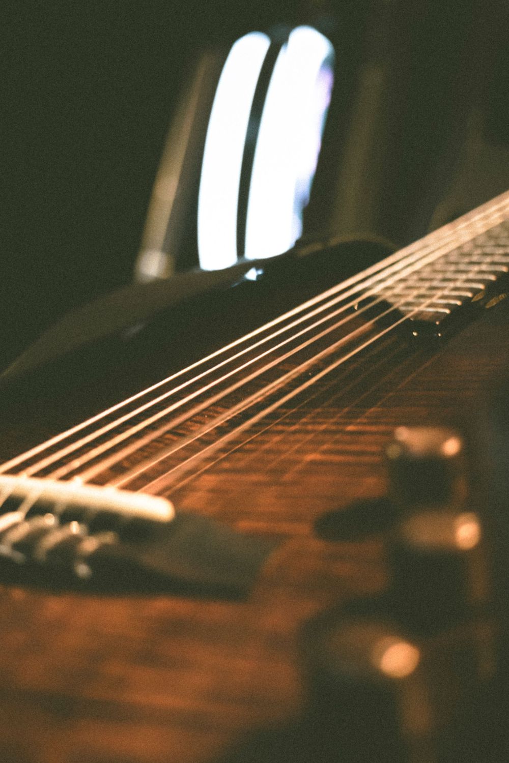 Close-up macro shot of acoustic guitar strings with soft lighting in background.