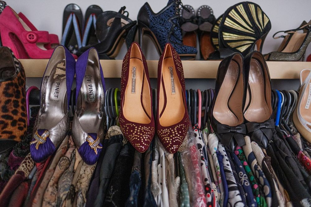 Collection of colorful women's shoes and boots arranged on closet shelves with various patterns and designs.