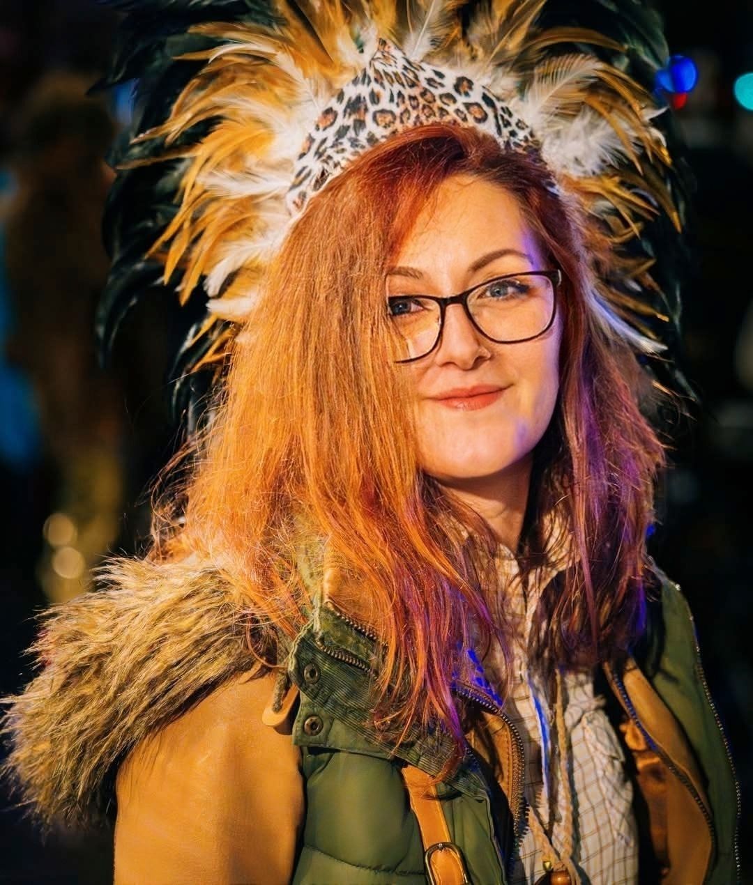Close-up portrait of a woman in an elaborate feathered carnival headdress and costume. Vivitu portrait
