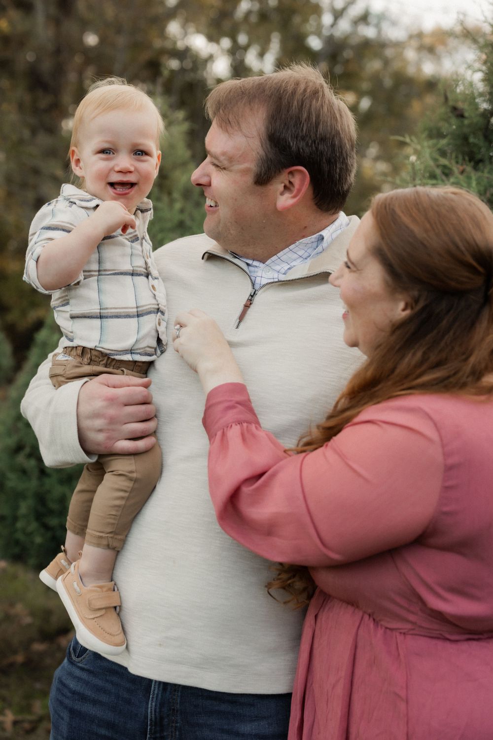 A happy family enjoying an outdoor photoshoot together in casual attire on an autumn day.