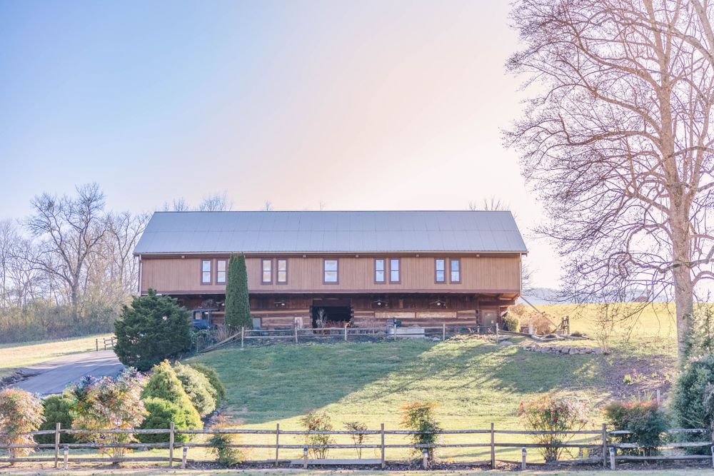Large rustic lodge venue situated on hillside with manicured lawn.