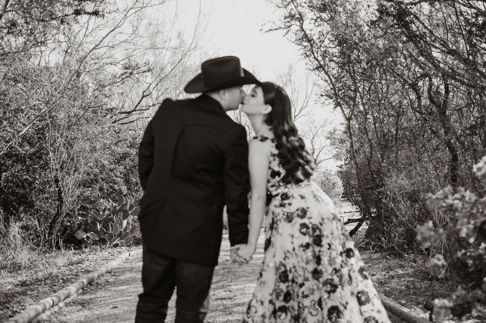 A romantic black and white photo showing a couple embracing on a nature path.