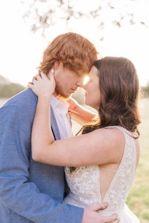 A tender moment between newlyweds backlit by golden sunlight.