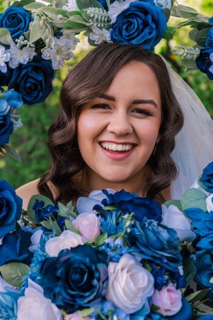 Beautiful wedding bouquet with vibrant blue roses and white flowers framing the scene.