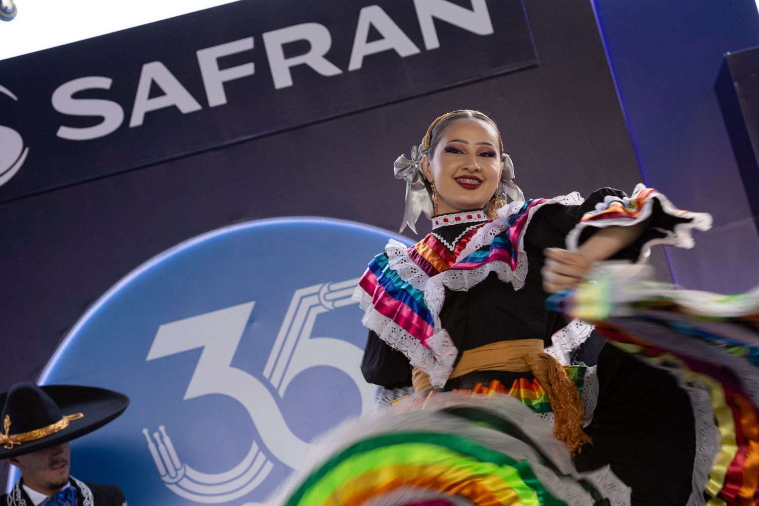 A dancer in colorful traditional Mexican attire performs at a Safran 35th anniversary celebration event.