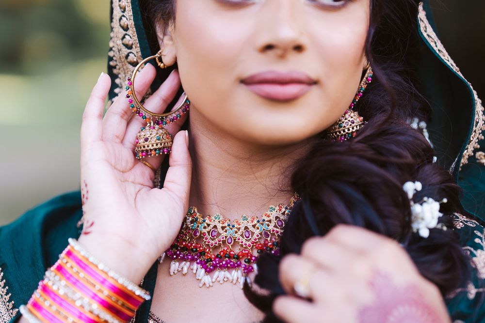 Traditional Indian bridal jewelry featuring an ornate pink and gold necklace with matching earrings and tikka headpiece.