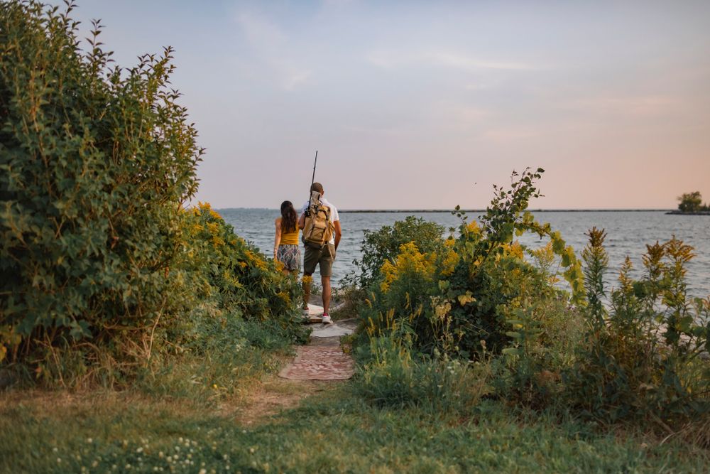 Couple arrives to a breakwall of Lake Ontario, preparing to go fishing. Kingston, ON.