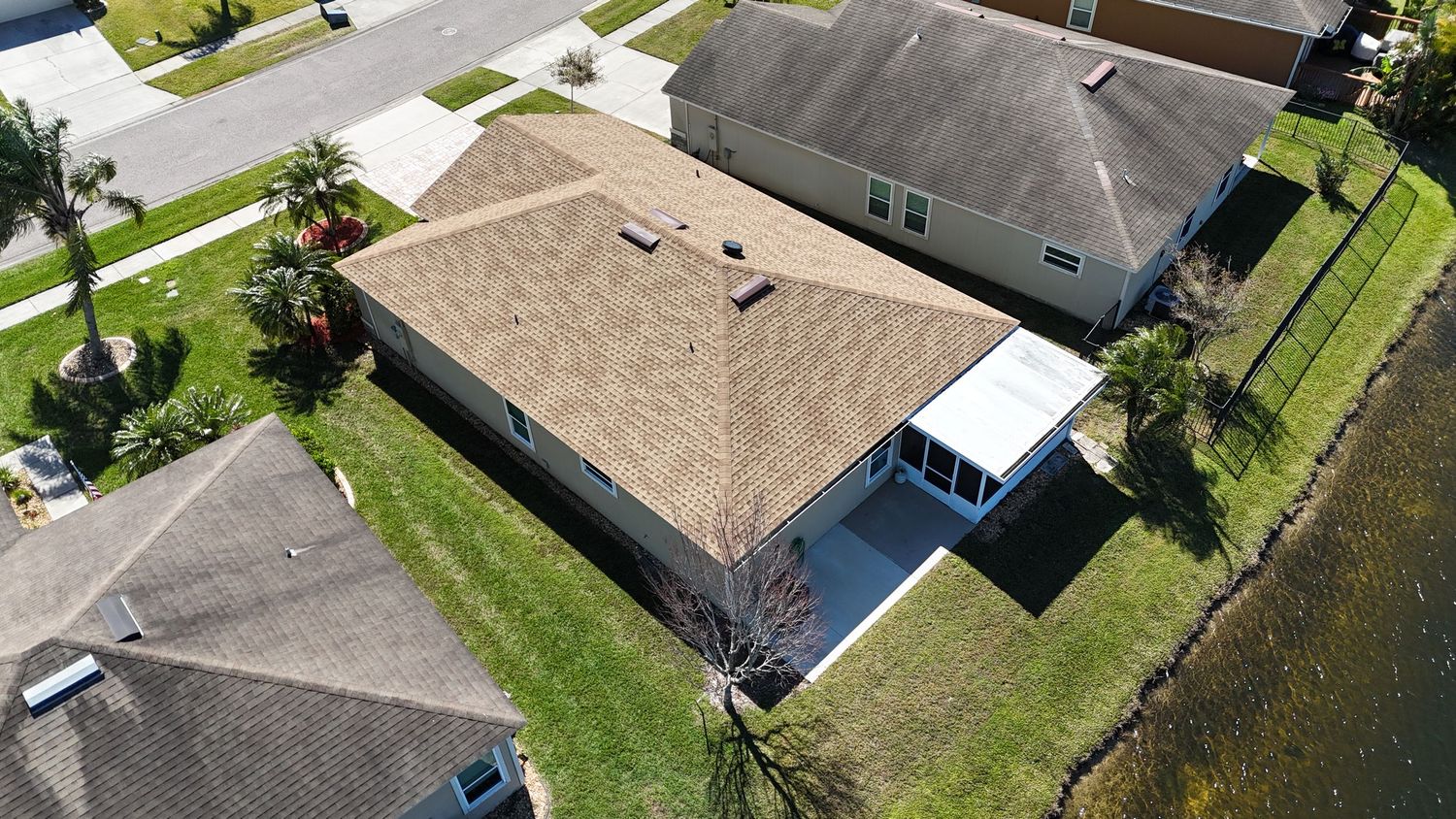 Overhead view of residential neighborhood showing tiled rooftops and backyard pools.