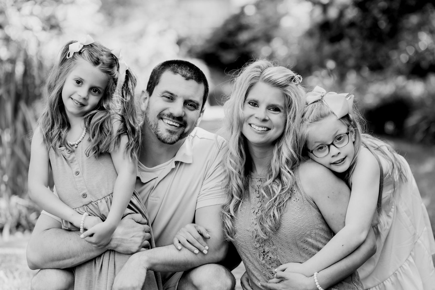 Black and white family portrait showing warm expressions and closeness.