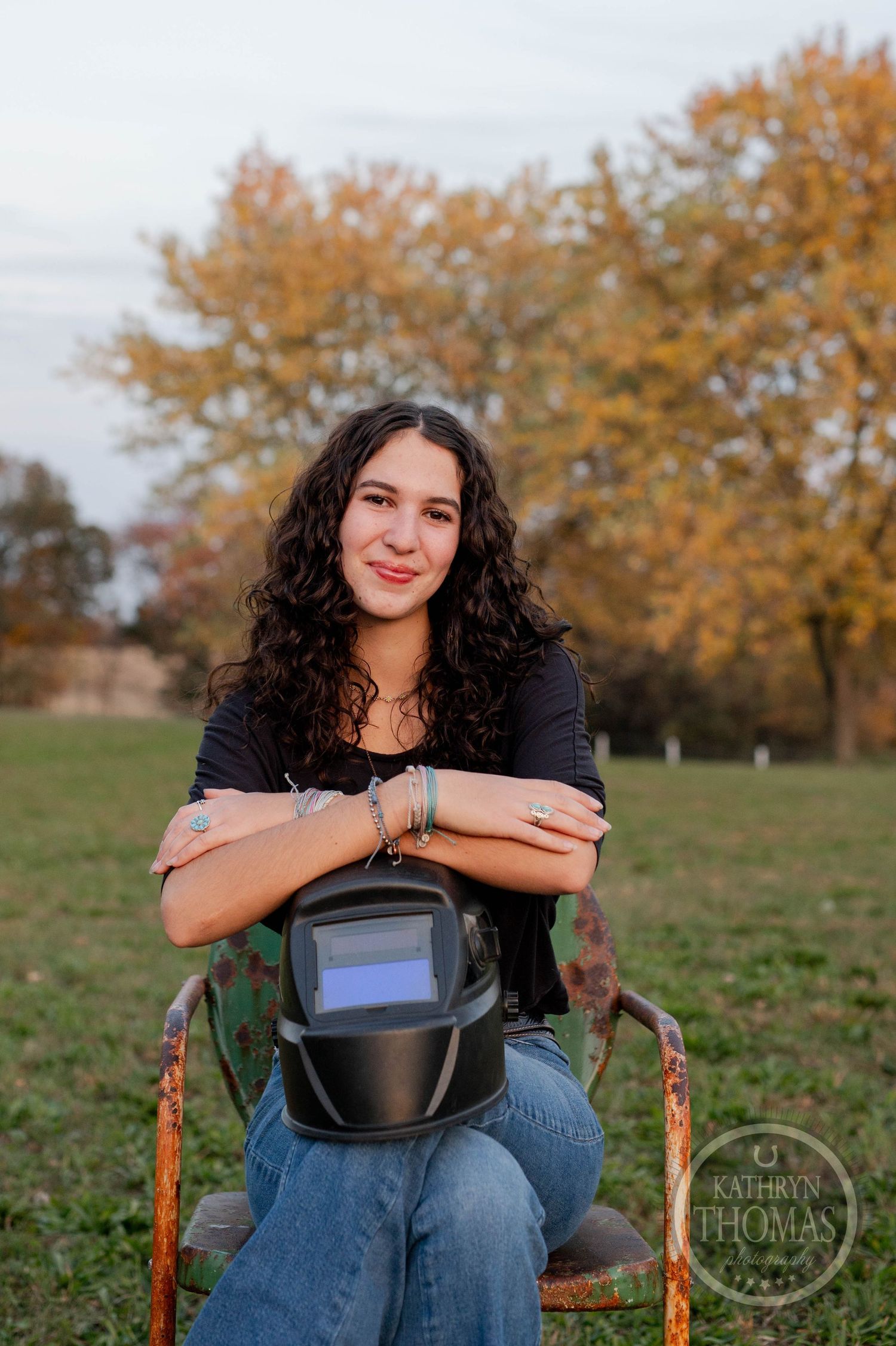 Casual outdoor portrait with welding helmet and autumn trees in the background.