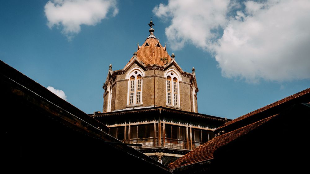 Historic architecture with ornate tower details and arched windows against a bright blue sky.