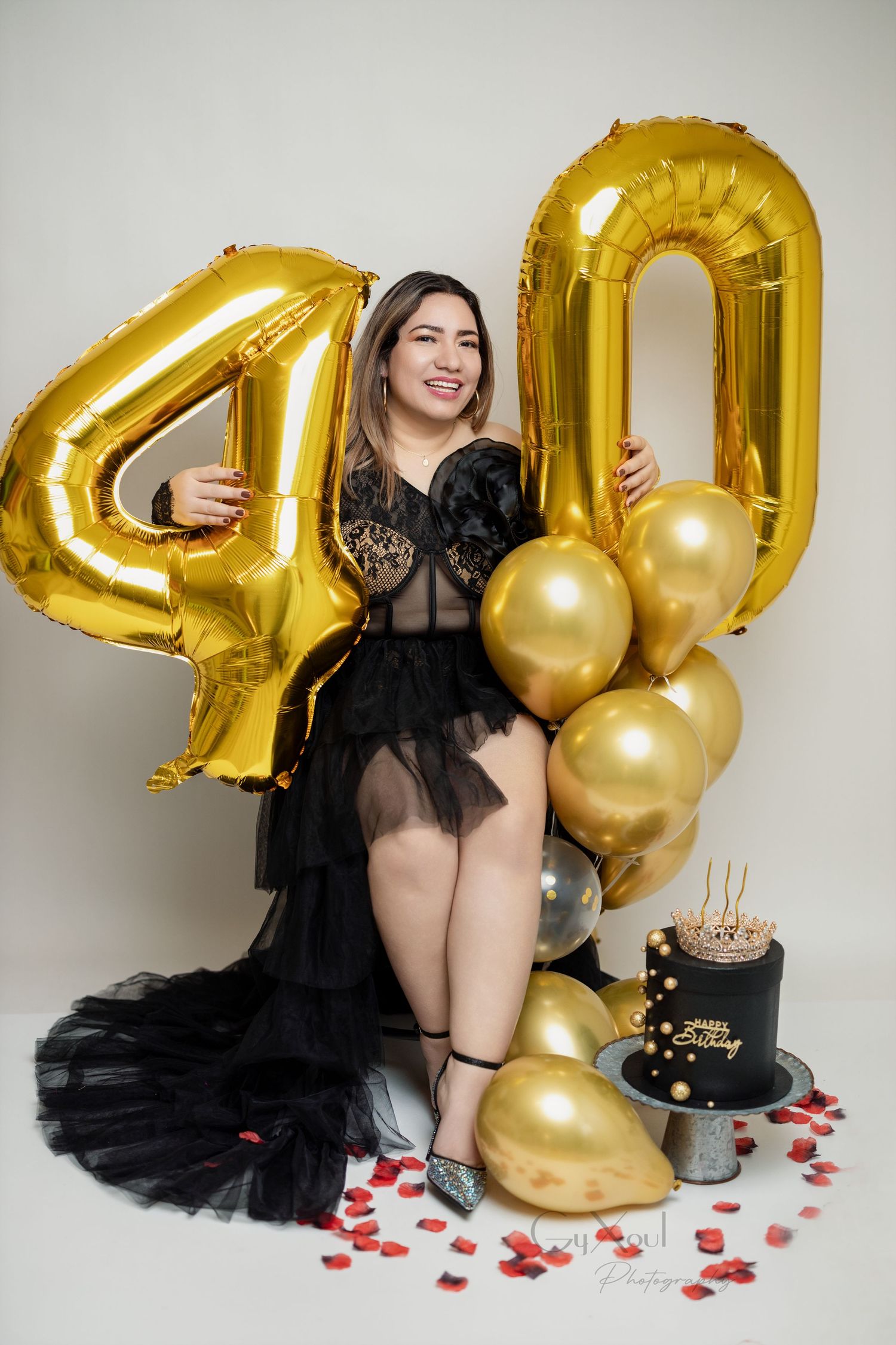 Milestone 40th birthday celebration with black dress, gold number balloons and festive decorations.