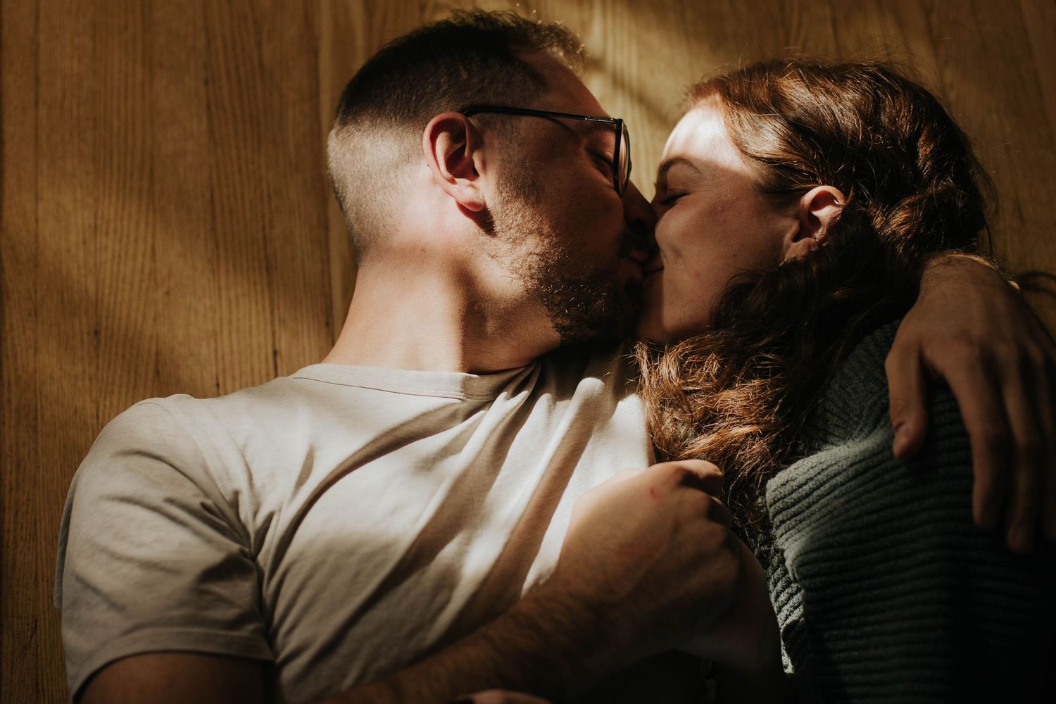 COuple laying on the floor, kissing while the light get into their house in Toronto