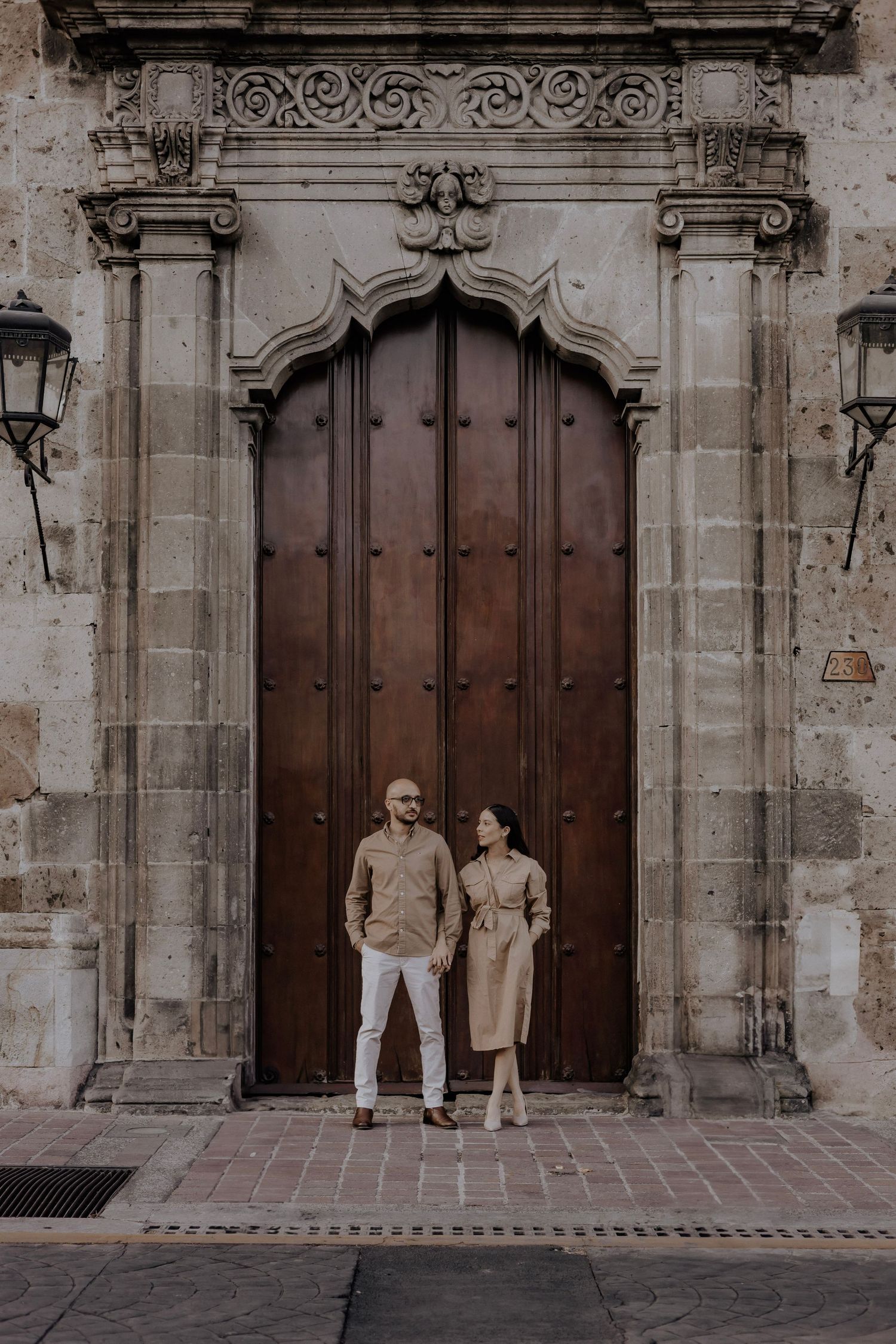 Couple poses outside large doors