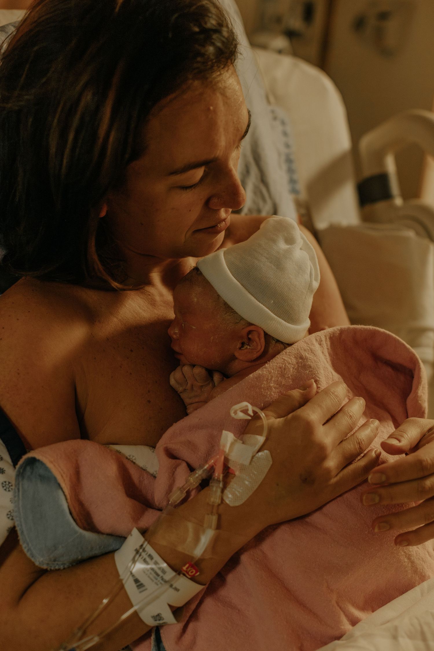 mother holding her newborn right after birth in the hospital room