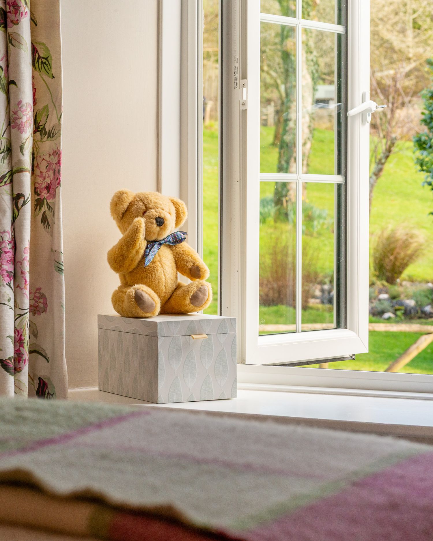 bedroom view with teddy bear and garden view taken near Fowey Cornwall