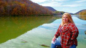 Lakeside photo shoot with mountain views and fall colors in the background.
