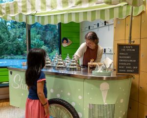 A customer ordering from a mint green ice cream truck window.
