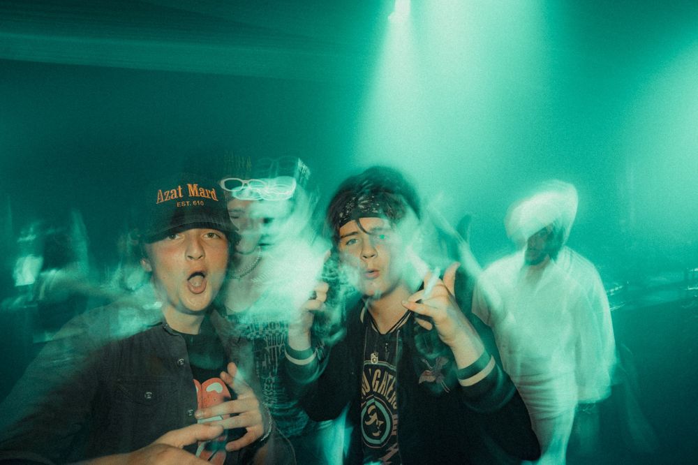 Club-goers enjoying a high-energy moment under green lighting.