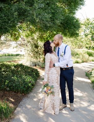 Couple sharing romantic moment in garden setting on their wedding day.