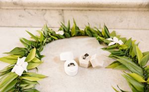 White and green leaf garland with shoes for wedding ceremony display.