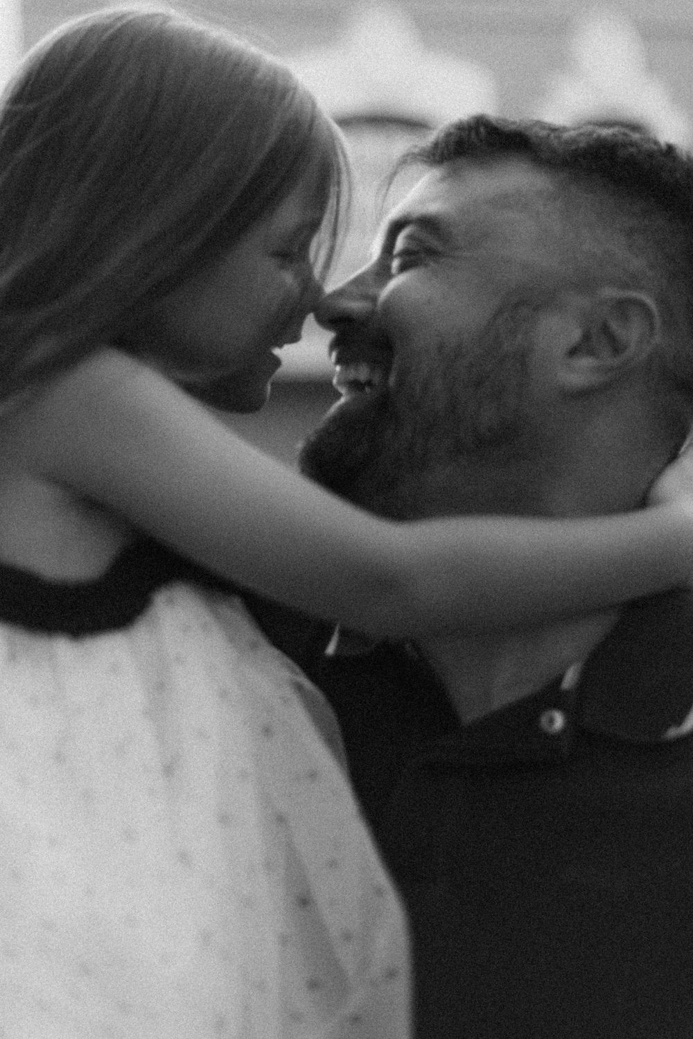 A tender black and white moment between parent and child as they share an intimate nose-to-nose embrace.