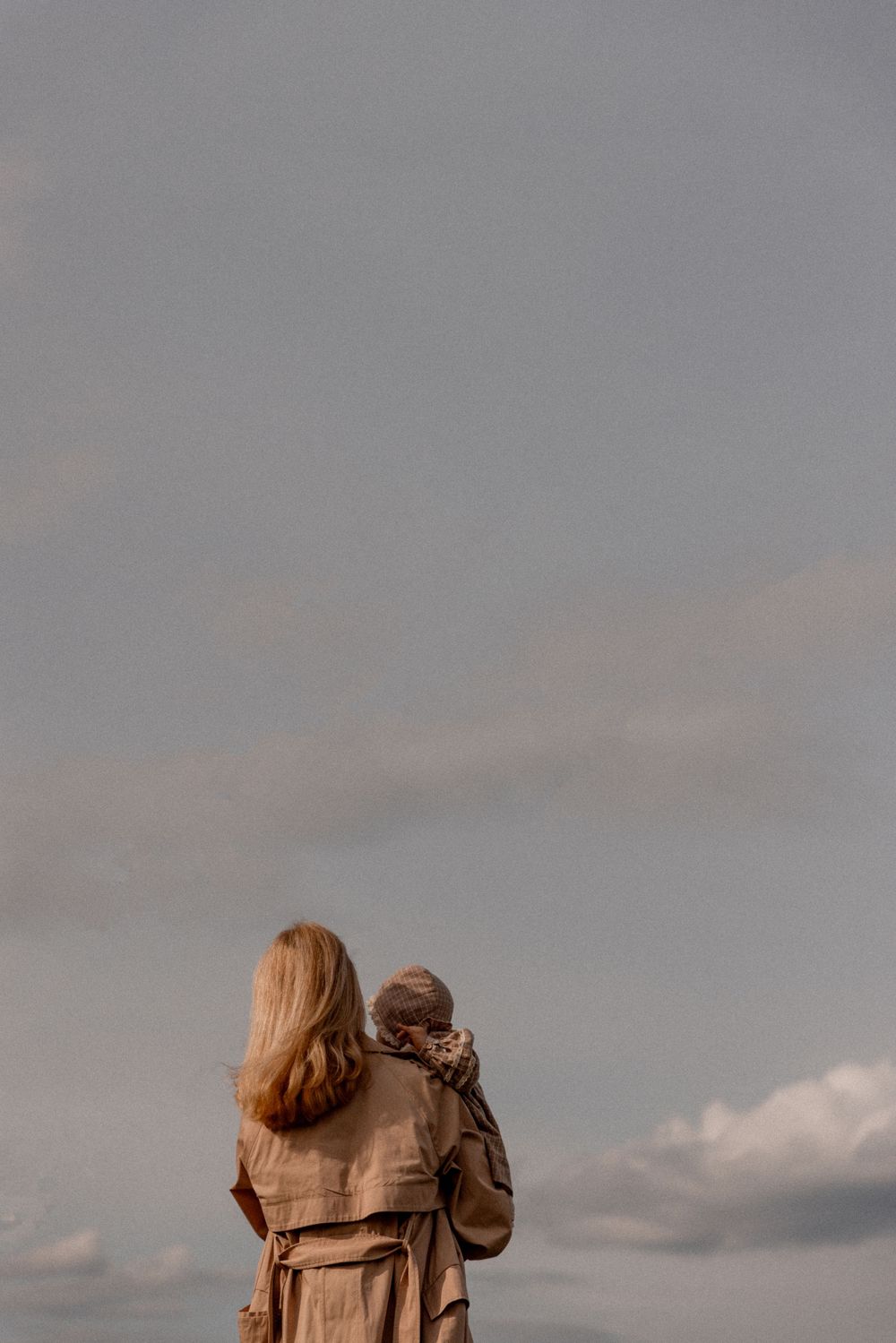 A silhouette against a cloudy sky shows a tender moment of connection.