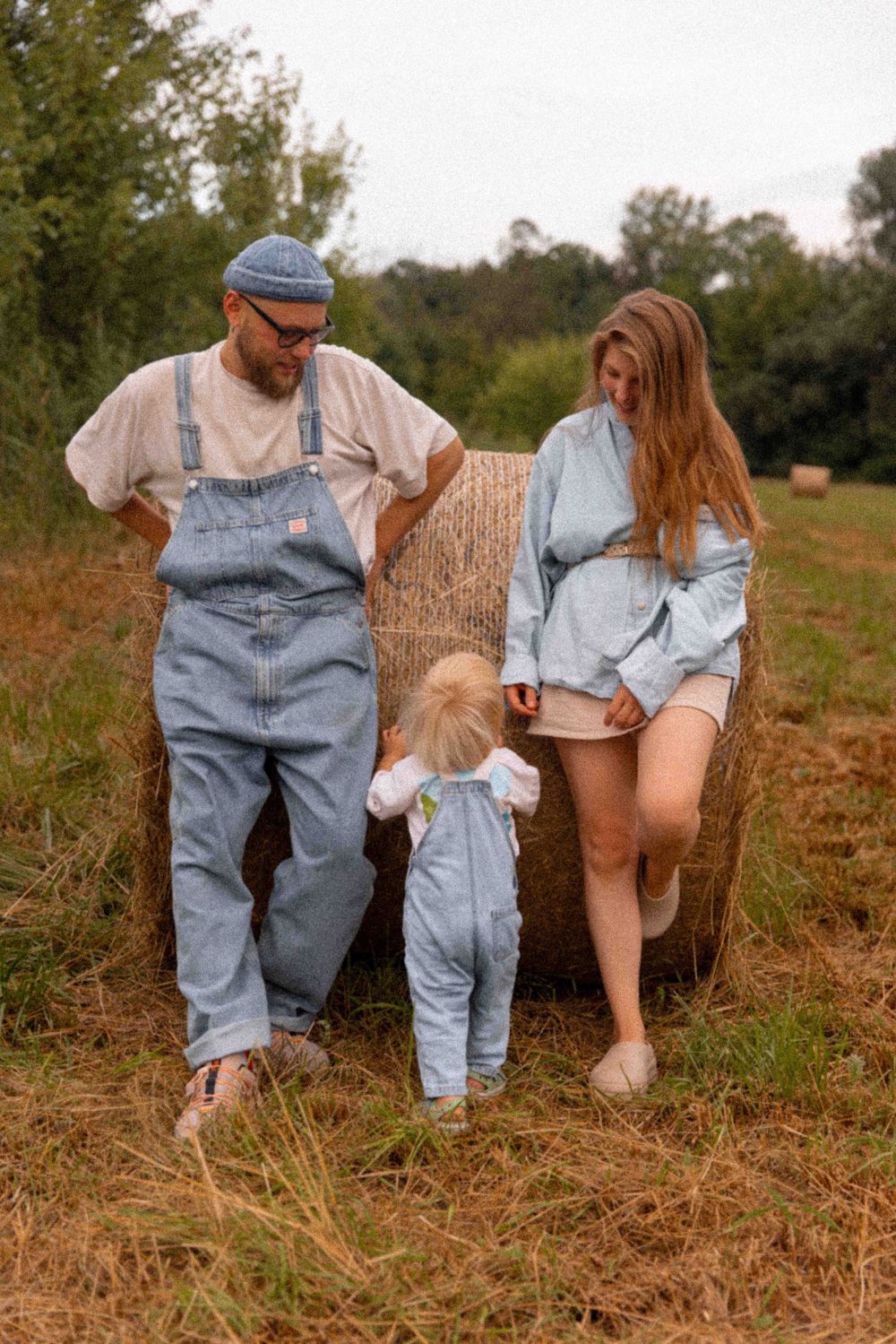 A carefree family walking together outdoors, coordinated in denim and casual wear.