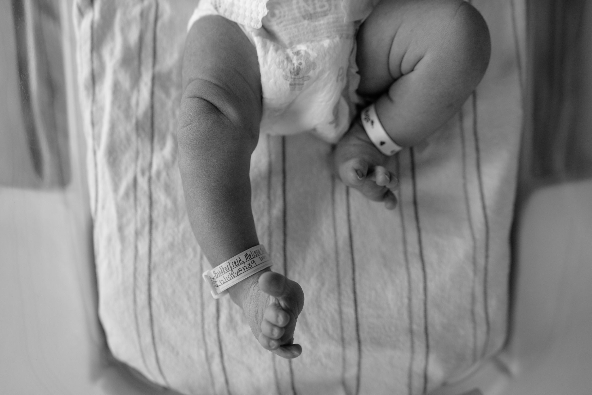 A black and white photo shows a person's hands holding and examining a small object.