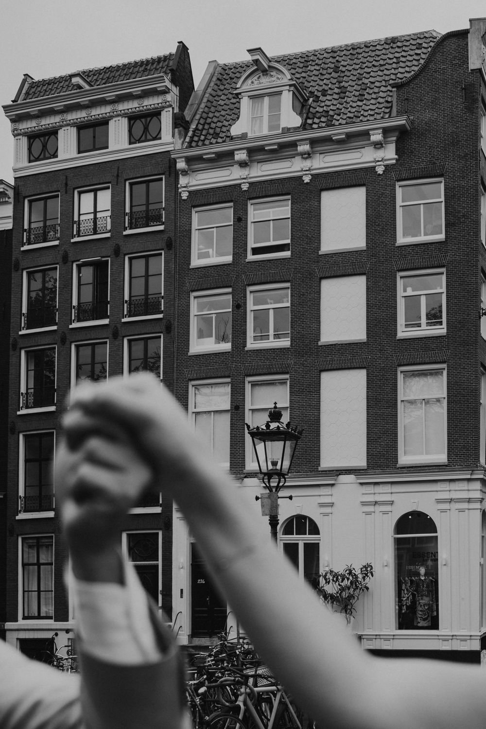 Traditional Dutch canal houses with distinctive architecture photographed in black and white in Amsterdam.
