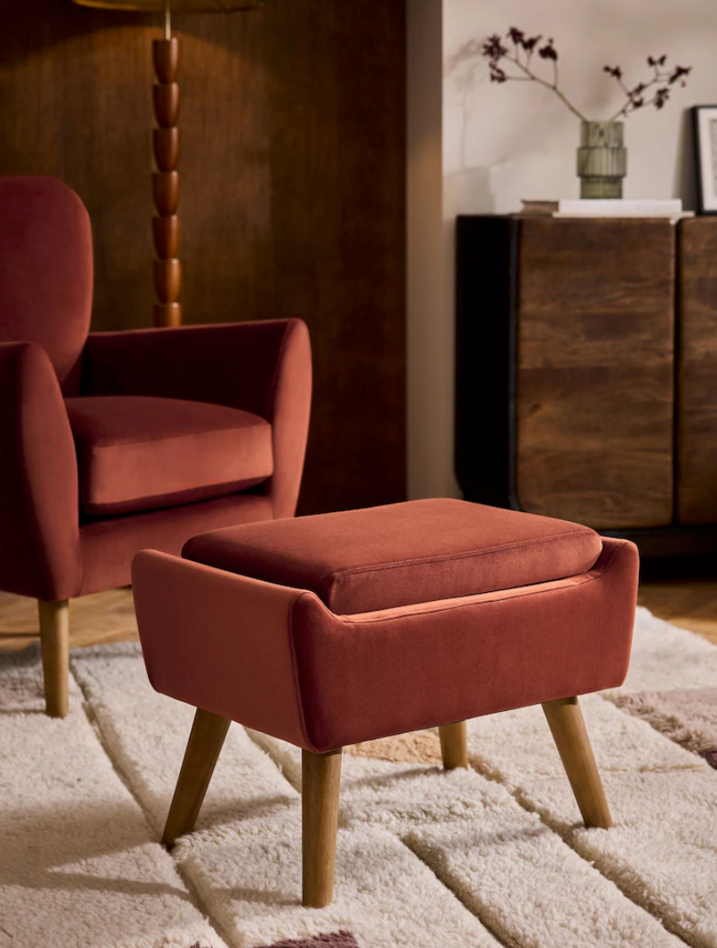 Sequence of photos showing a modern terracotta-colored armchair with wooden legs on a plush cream carpet.