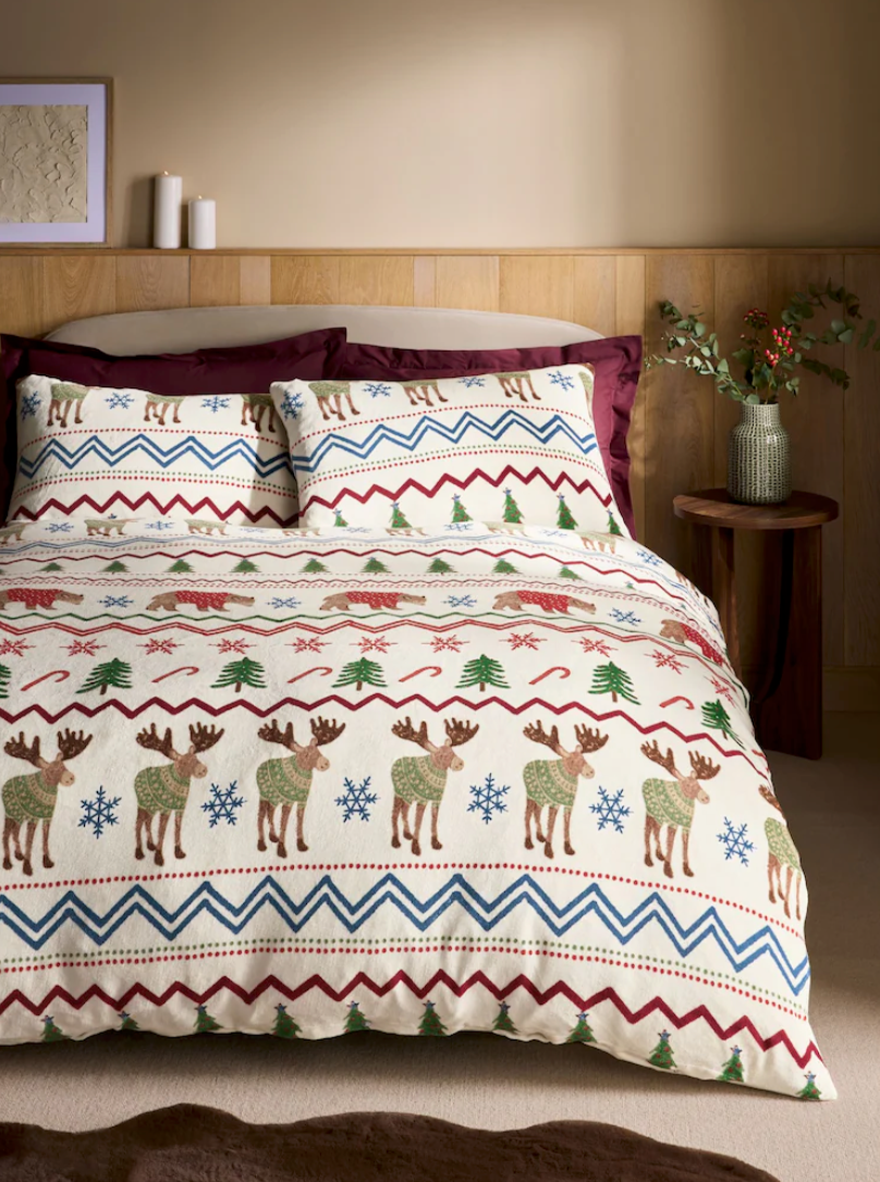 Holiday bedding set featuring Nordic style pattern with reindeer, trees and snowflakes in red, blue and green colors.