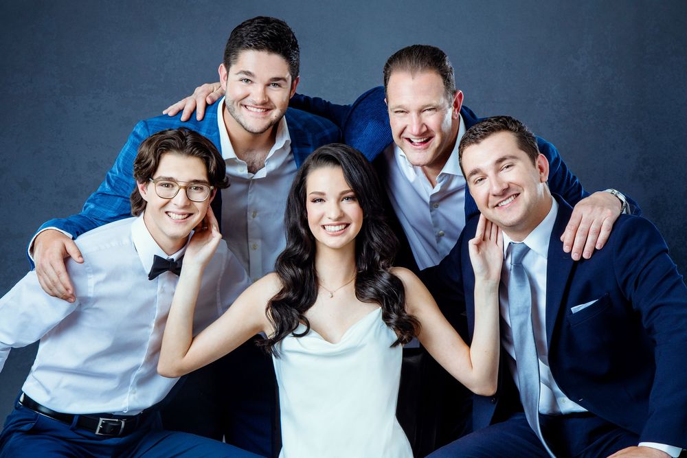 Family portrait of a father and his four children with his daughter in the middle taken in the studio for Father's Day.