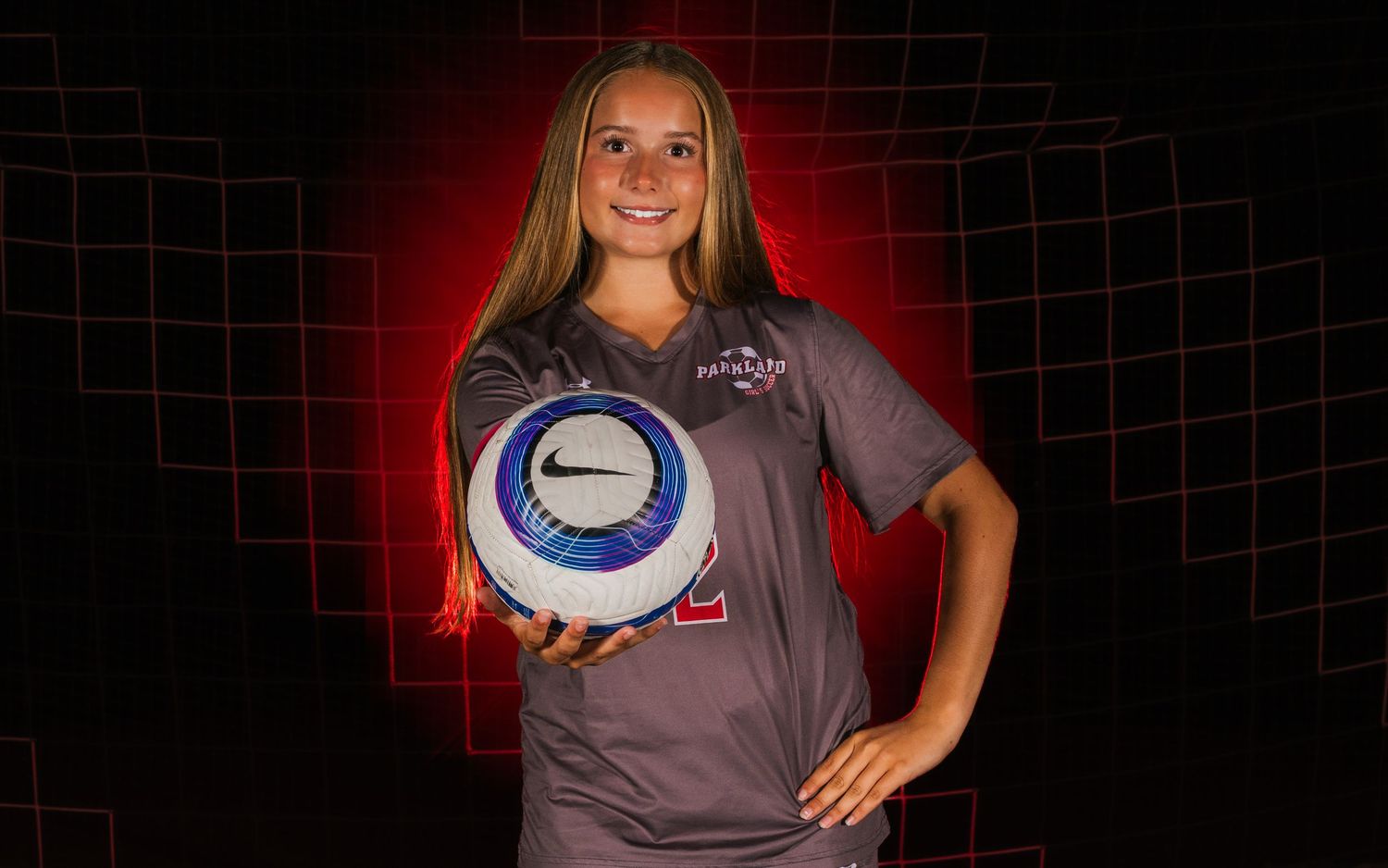 Parkland girls soccer player Media Day portrait with red halo lighting, by Deanna Fox, SportsFox Photography, Hershey PA