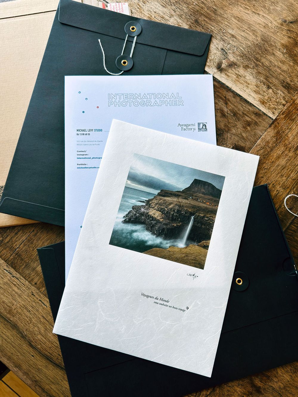 Award-winning fine art photography print with certificate, displayed on a dark envelope on a wooden table.