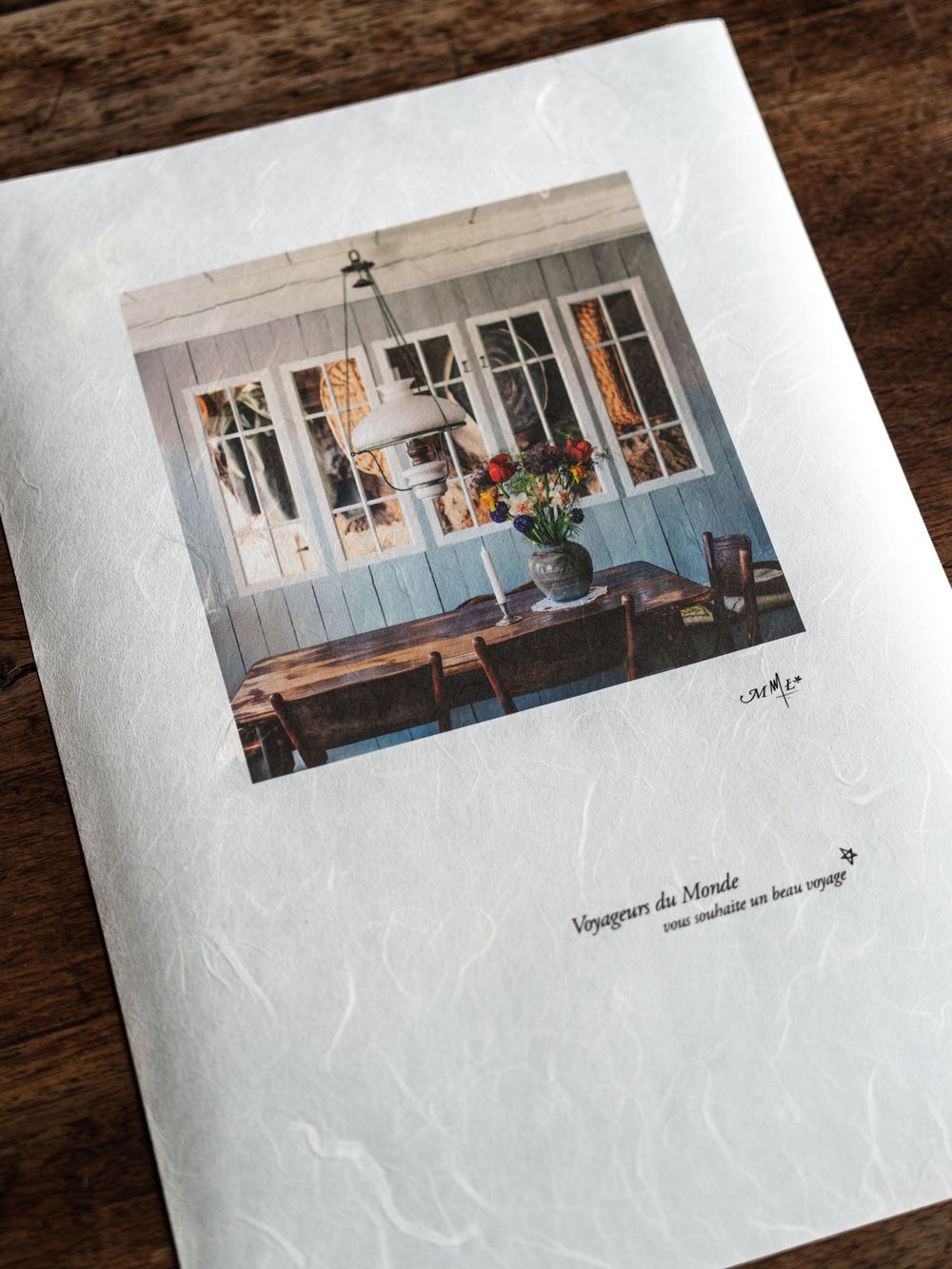 A greeting card with a cozy interior photo on textured paper, featuring French text and a floral arrangement on a wooden table.
