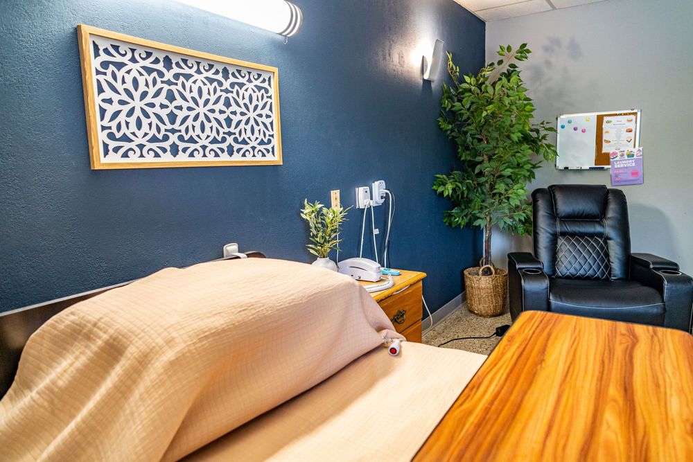 Serene room with a bed, blue accent wall, decorative panel, and black leather chair for residents and visitors in assisted living