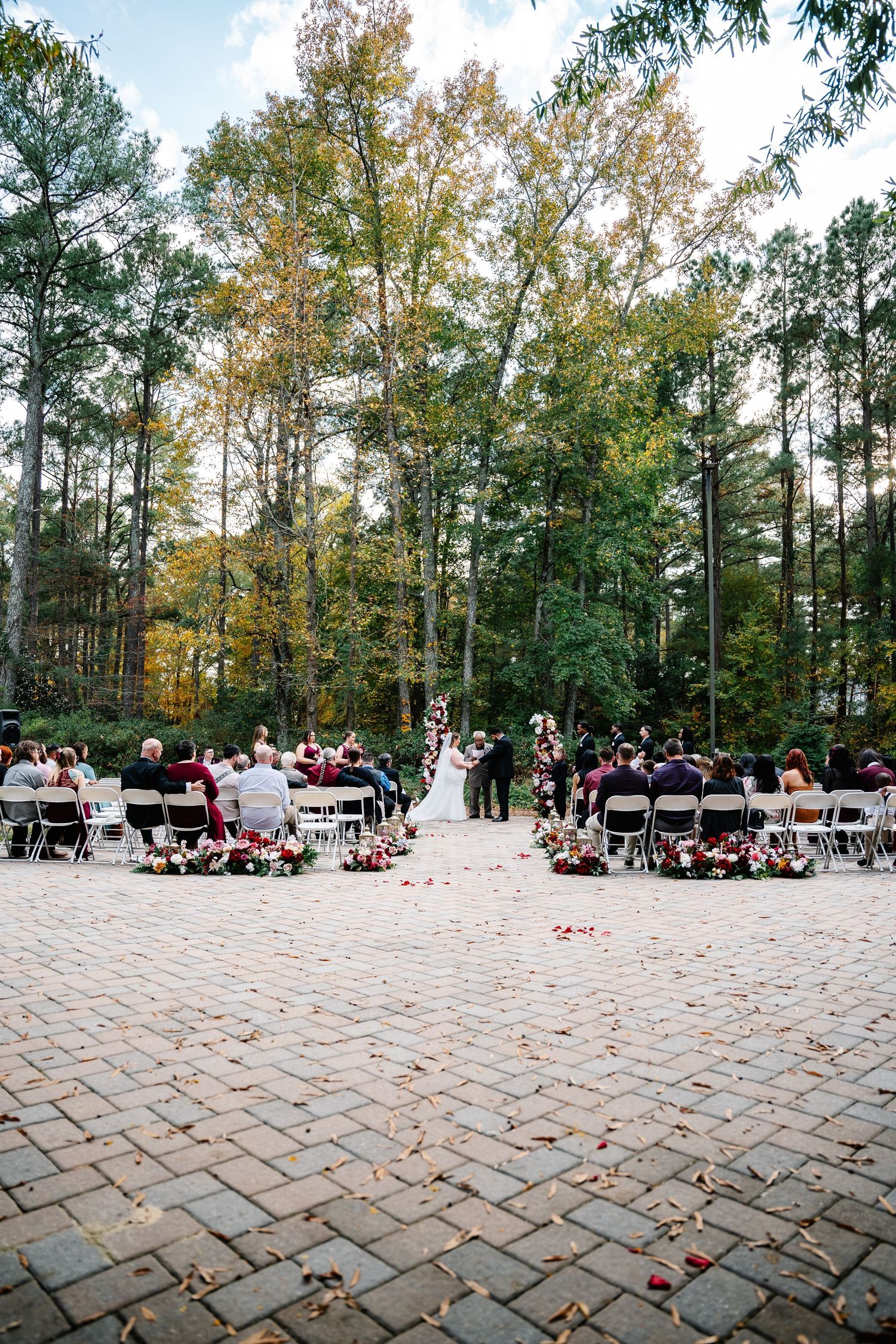 fayetteville wedding on brick pavement with greenery backdrop.