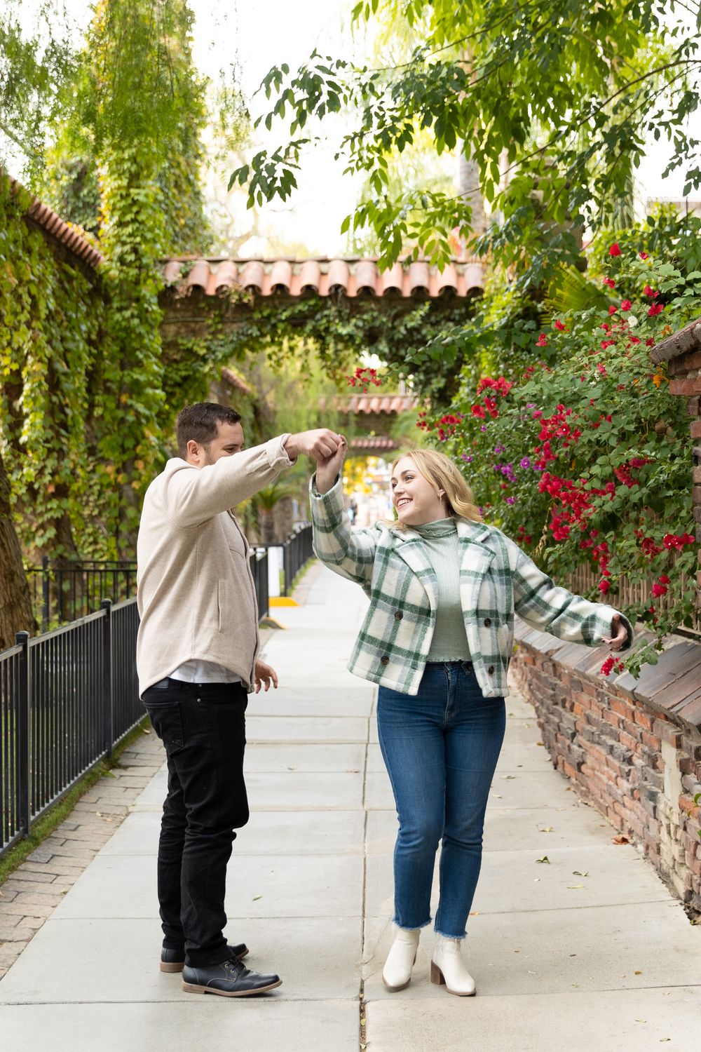 A man twirling his fiance during their engagement photo shoot