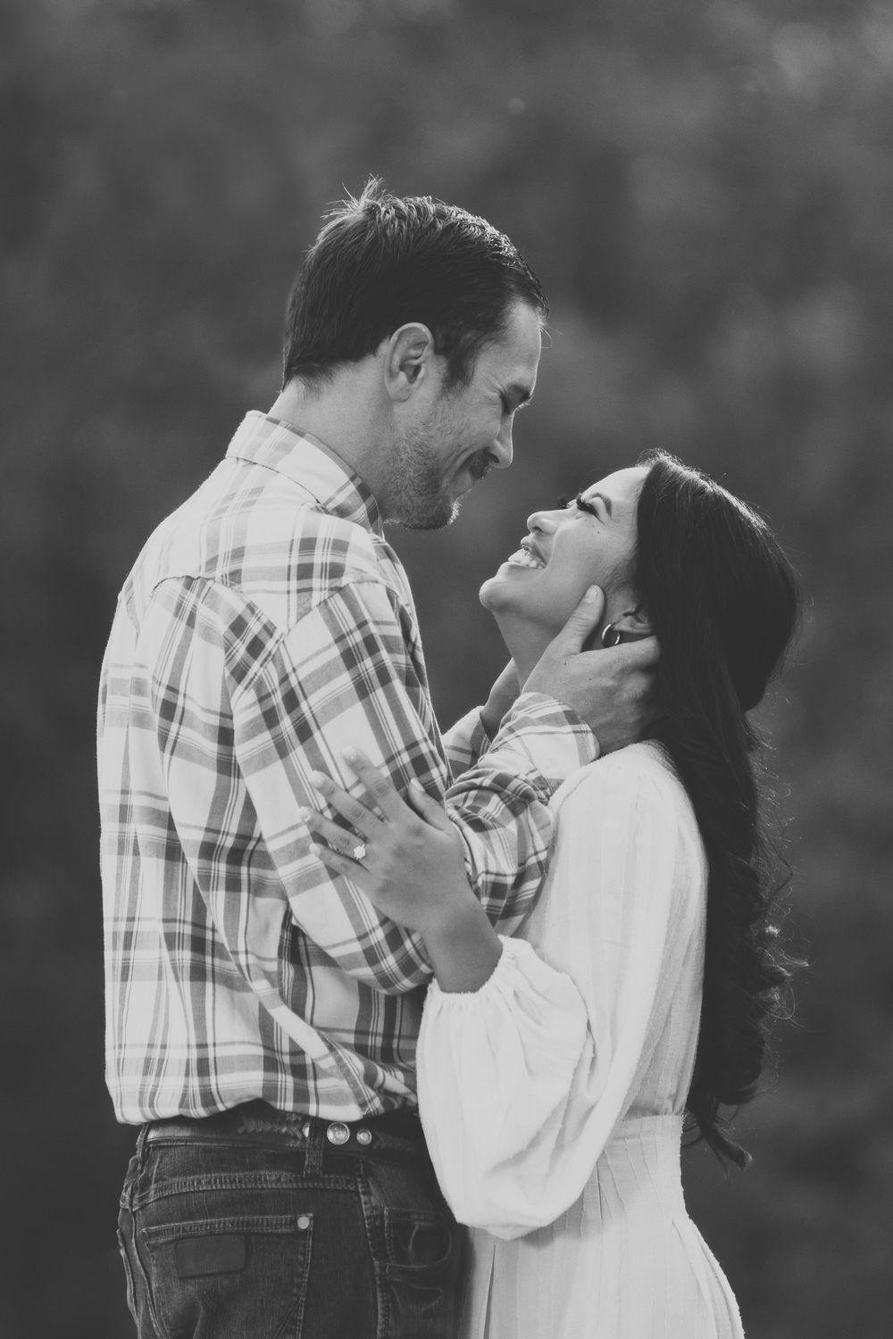 A black and white photo of a couple embracing one another during their engagement photo session