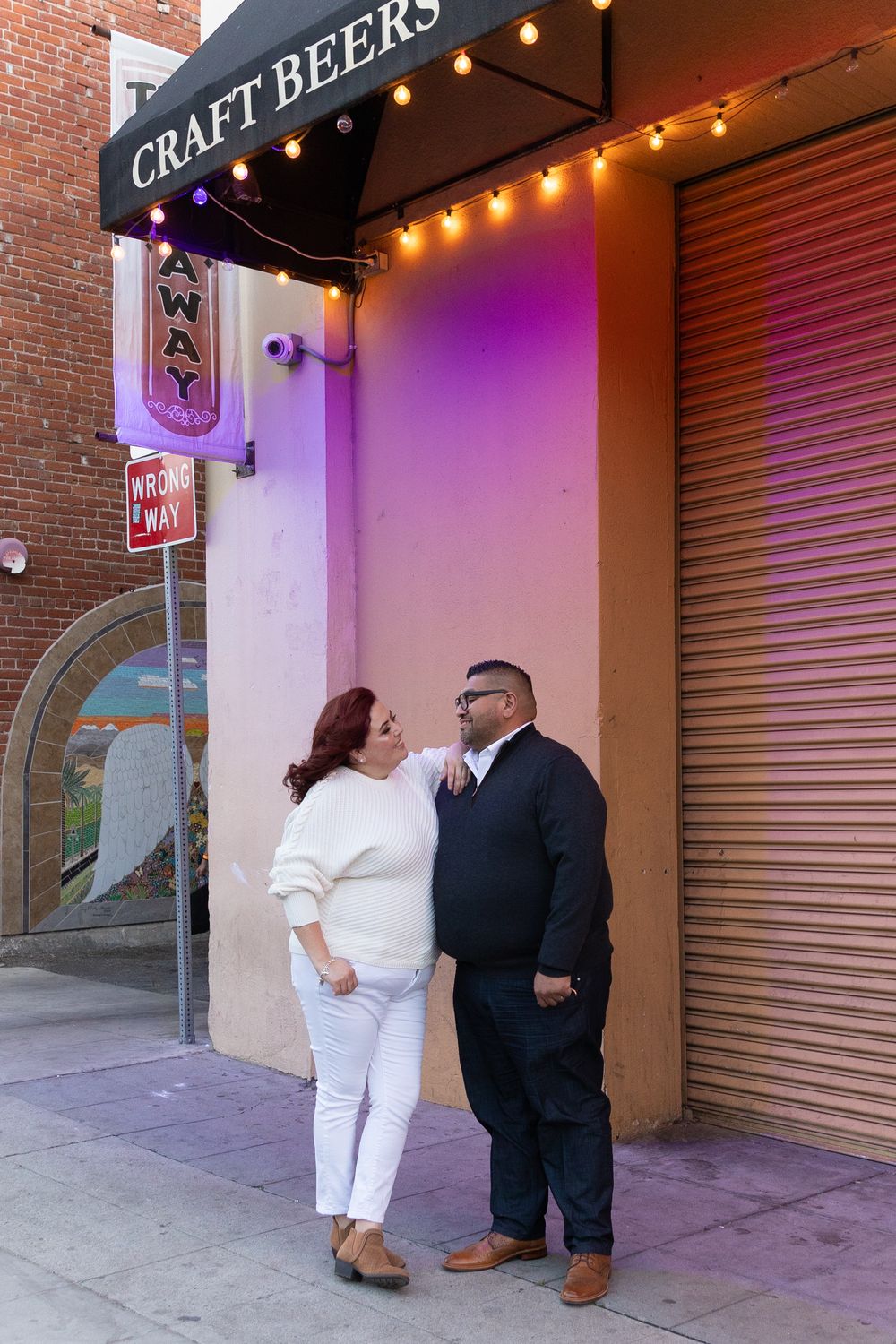 Engaged couple standing and smiling by one another during their Riverside engagement photo shoot
