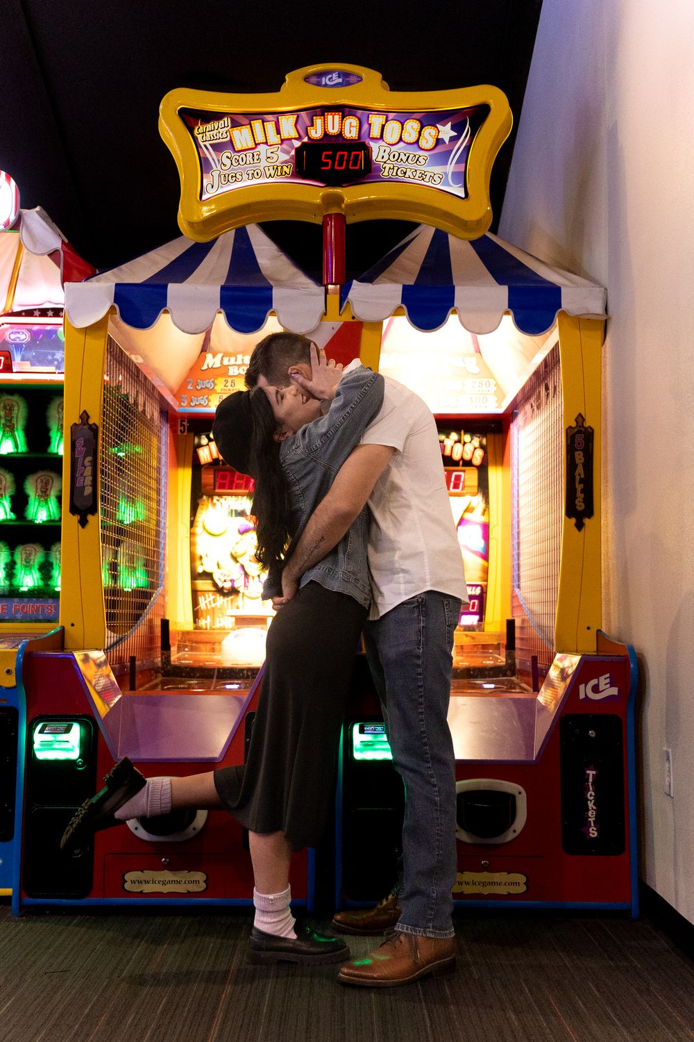 A couple hugging one another during their arcade photo session for their engagement photos.