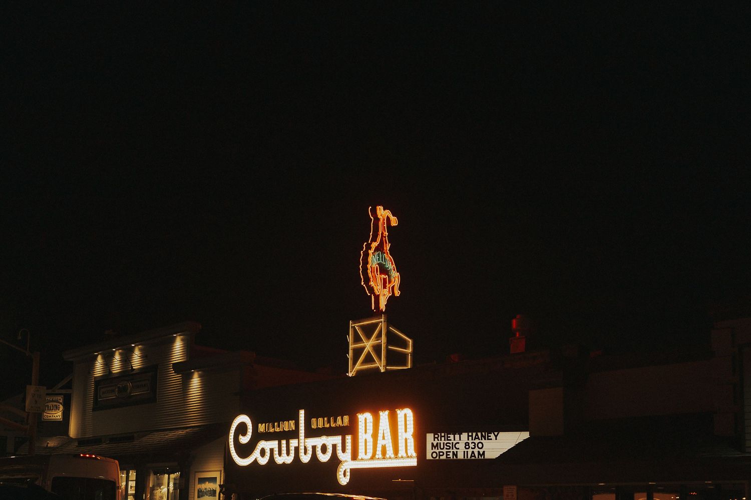 Million Dollar Cowboy Bar neon sign glowing at night in Jackson Hole, Wyoming.