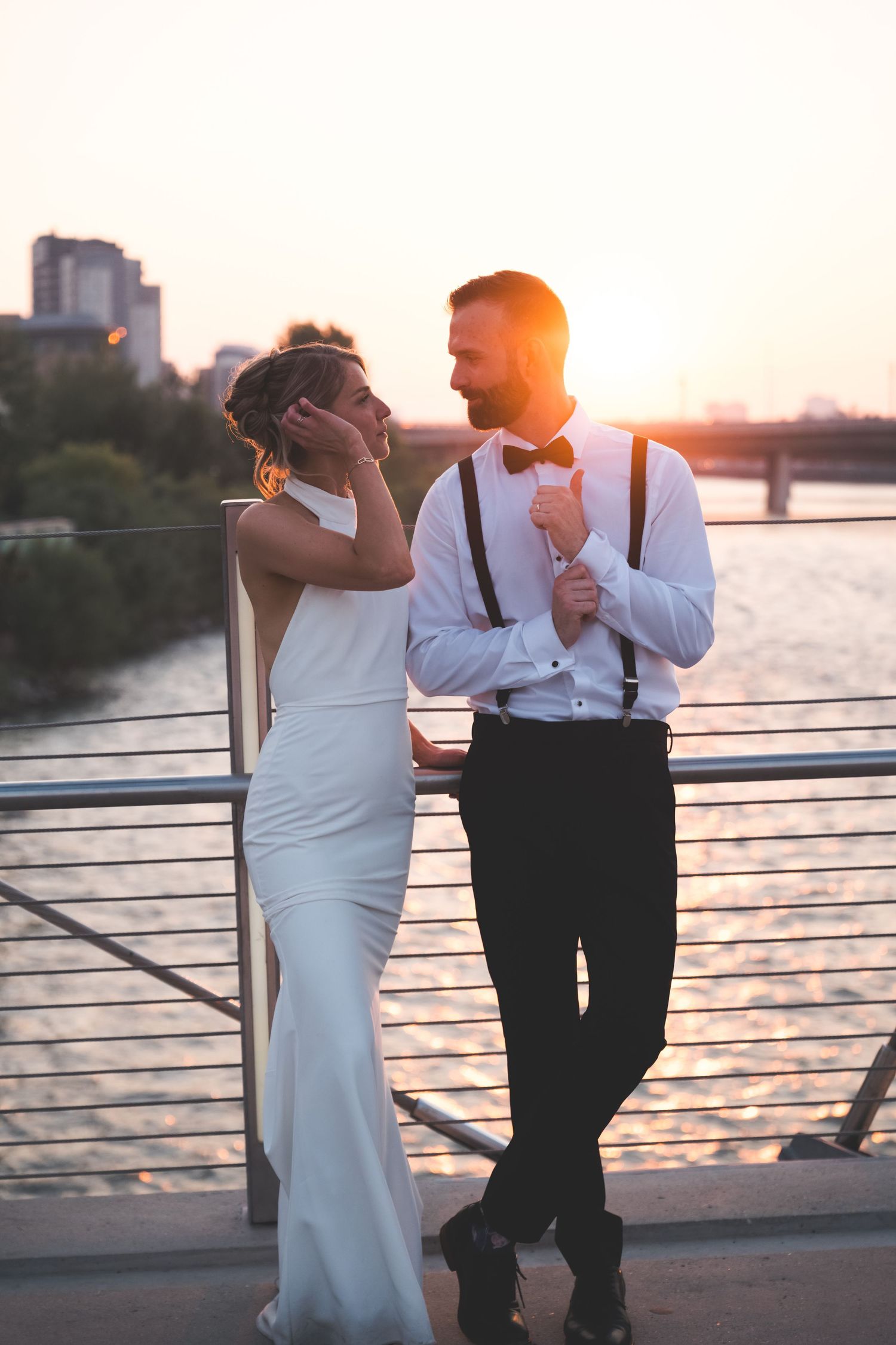 A bride and groom share a romantic moment surrounded by lush green trees and foliage on their wedding day.