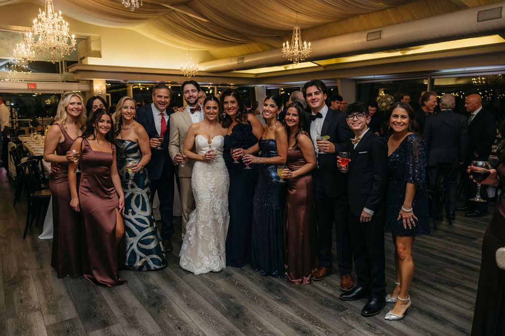 Wedding couple with guests posing together in elegant ballroom reception venue Meson Sabika in Naperville