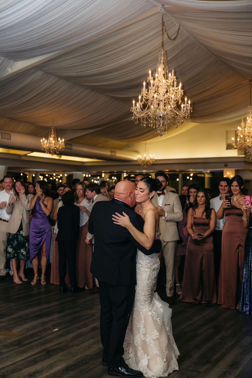 Bride and father share father daughter dance under crystal chandeliers in elegant draped wedding reception venue Meson Sabika in Naperville