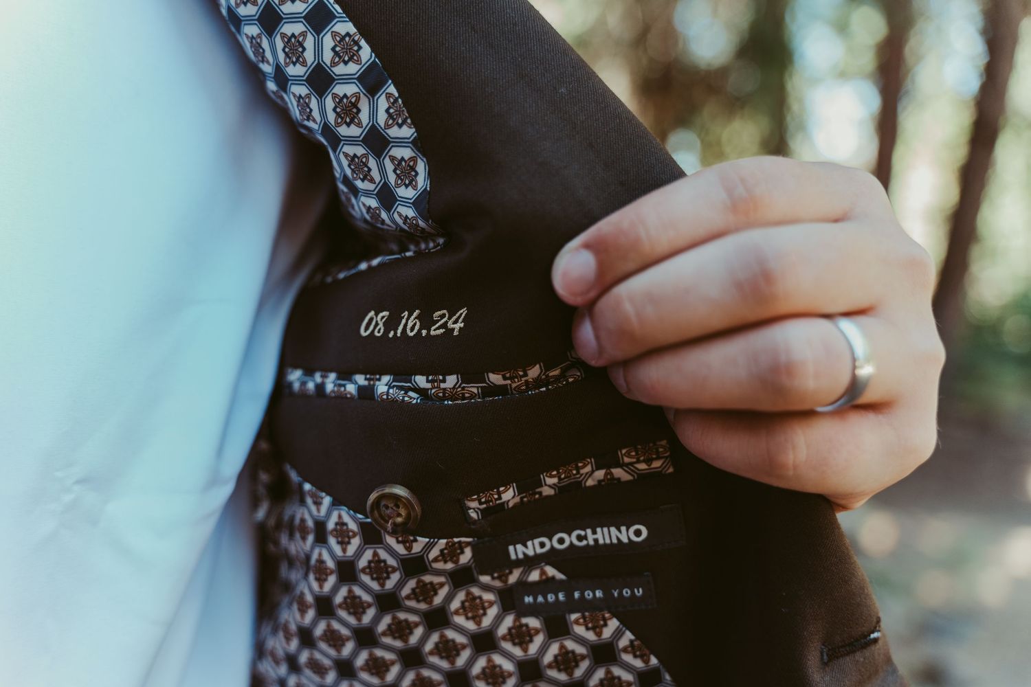 Close-up of groom's custom Indochino suit jacket lining engraved with wedding date 08.16.24.