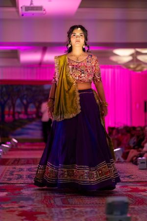 Model walks the runway during the Azalea spring fashion show 2026 in a traditional Indian navy blue lehenga with embroidered details.